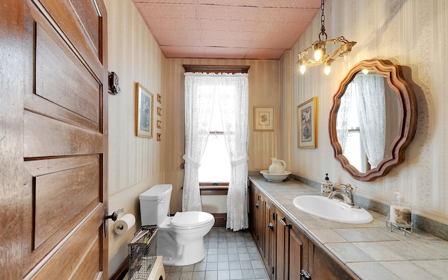 bathroom featuring wallpapered walls, tile patterned floors, toilet, and vanity