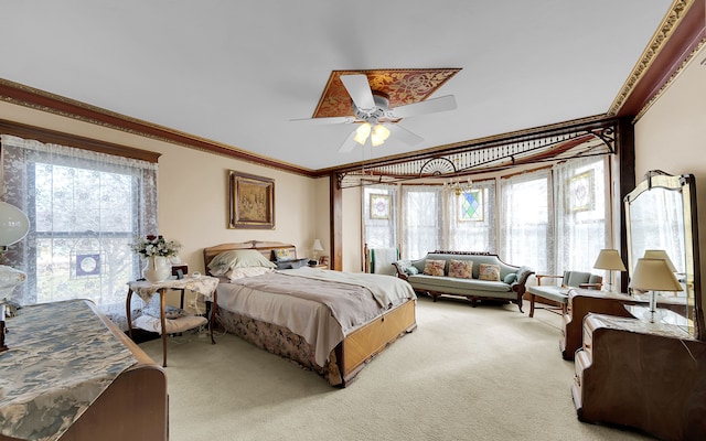 bedroom with light colored carpet, crown molding, and ceiling fan