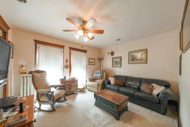 living area featuring a ceiling fan and carpet