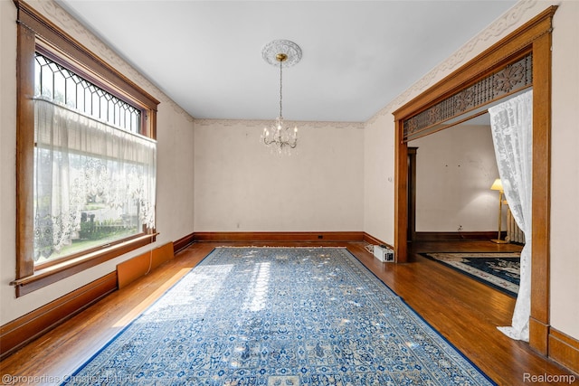 407 Westminister St, Marine City, MI 48039 - unfurnished room with wood finished floors, healthy amount of natural light, a chandelier, and baseboards