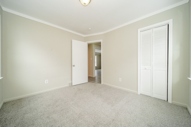 unfurnished bedroom featuring a closet, carpet floors, baseboards, and ornamental molding