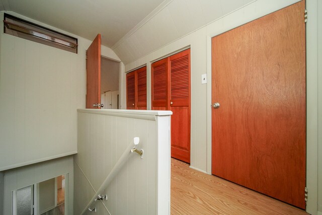 hall featuring an upstairs landing, lofted ceiling, and light wood-style flooring