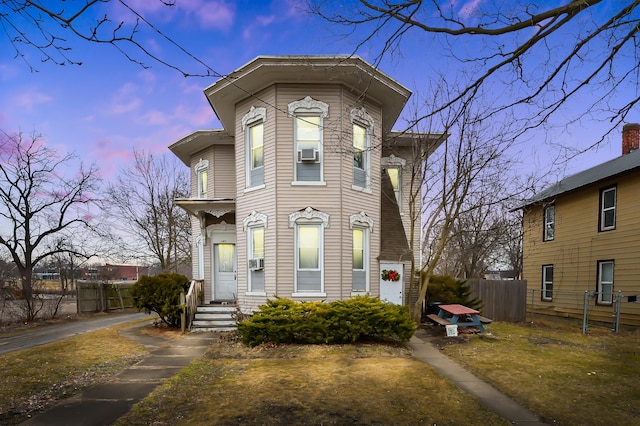 view of front of property with cooling unit and fence