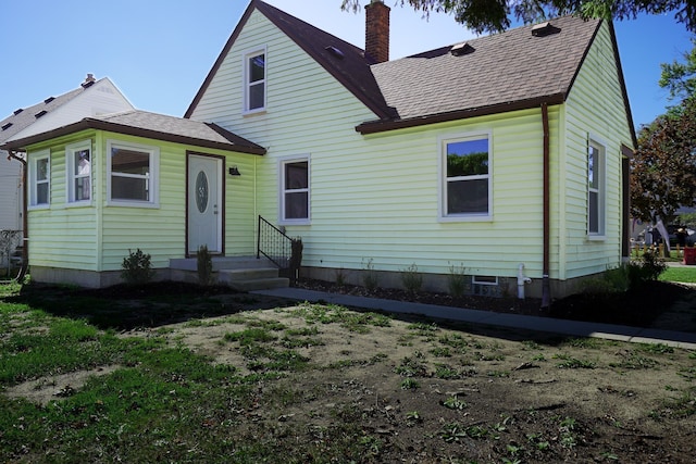 view of front of home featuring a chimney and a shingled roof