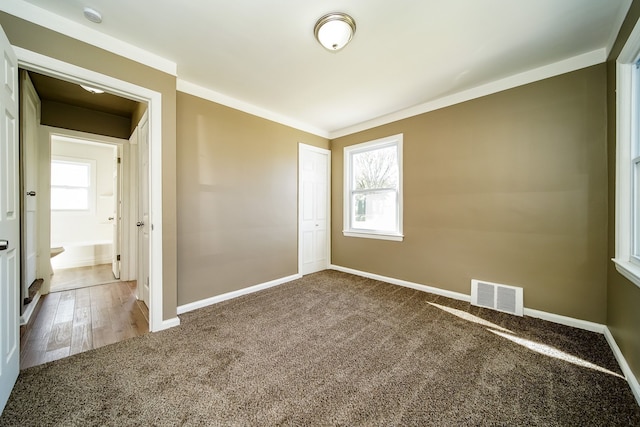 empty room featuring visible vents, baseboards, a healthy amount of sunlight, and carpet flooring