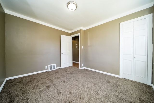 unfurnished bedroom featuring visible vents, baseboards, carpet, and a closet