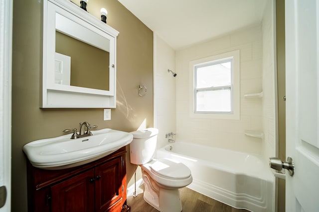 bathroom with toilet, vanity,  shower combination, and wood finished floors