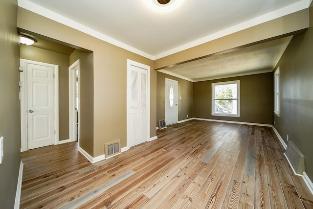 unfurnished bedroom featuring visible vents, baseboards, a closet, and hardwood / wood-style flooring