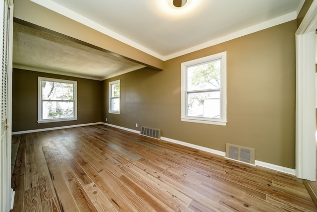 empty room featuring visible vents, baseboards, and hardwood / wood-style floors