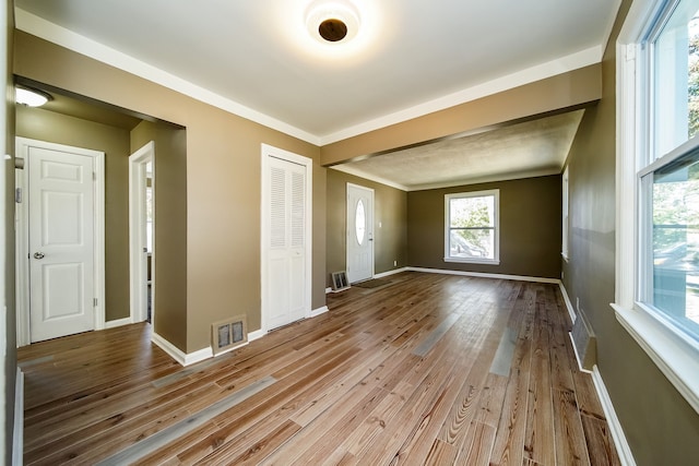 spare room featuring visible vents, baseboards, and wood finished floors