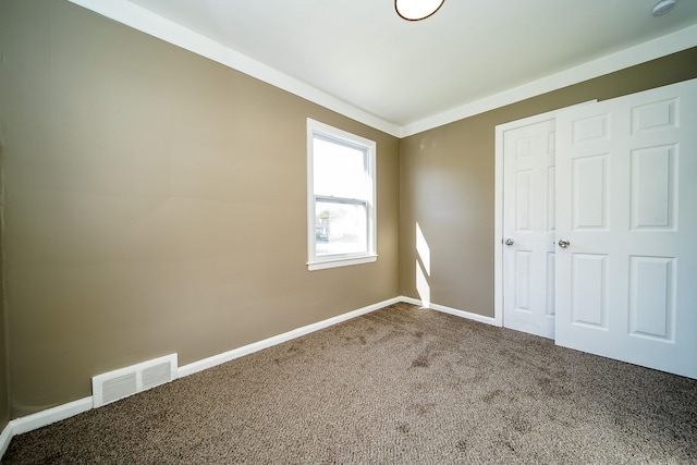 unfurnished bedroom featuring visible vents, carpet floors, and baseboards