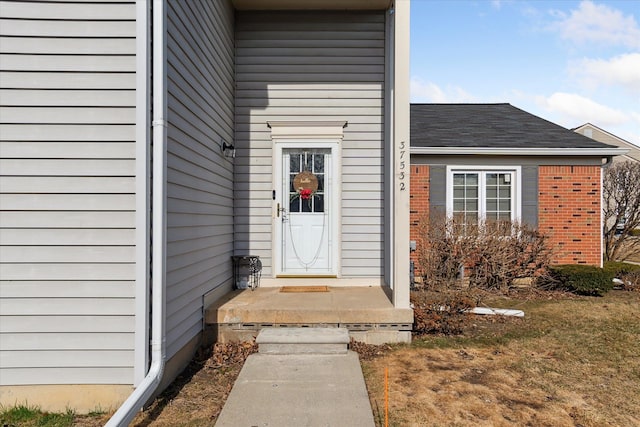 doorway to property with brick siding