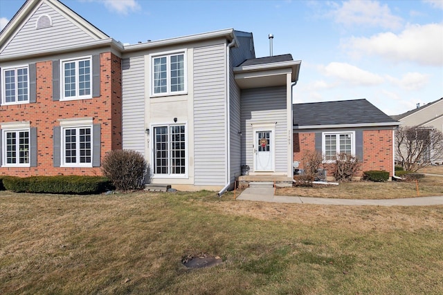 view of front of home featuring brick siding and a front yard