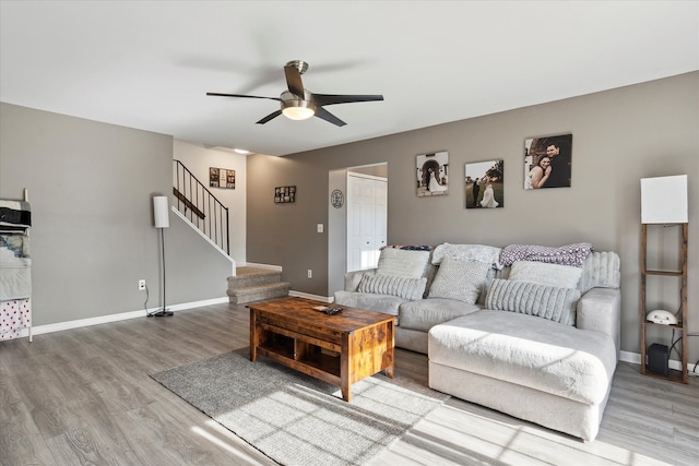 living area featuring stairs, baseboards, and wood finished floors