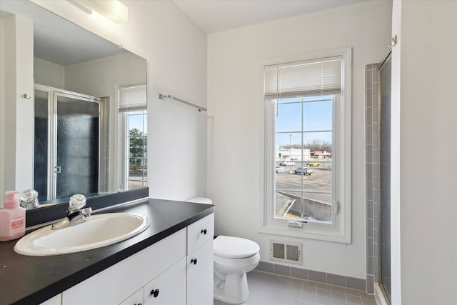 bathroom featuring visible vents, plenty of natural light, toilet, and a shower stall