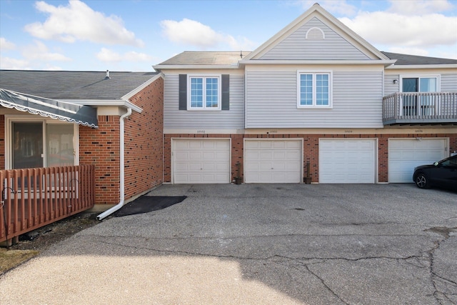 view of front of home featuring an attached garage, brick siding, and driveway