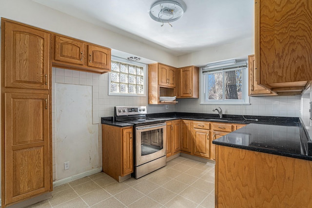 kitchen featuring electric range, brown cabinets, backsplash, and a sink