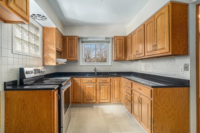 kitchen with a sink, electric range, decorative backsplash, and brown cabinetry