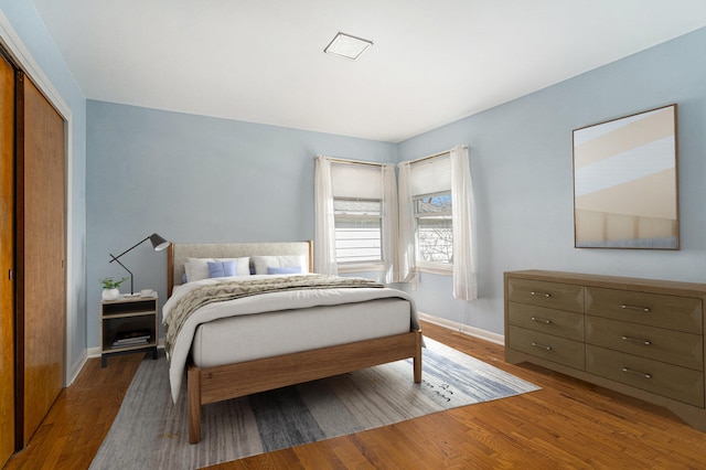 bedroom featuring a closet, baseboards, and wood finished floors