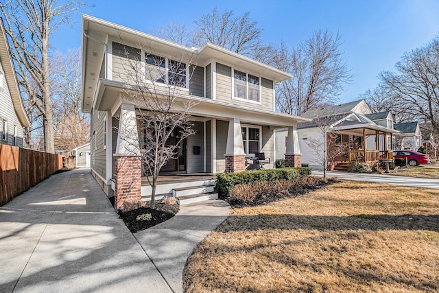 american foursquare style home with a porch, fence, a garage, and driveway