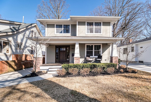 american foursquare style home with a porch and fence