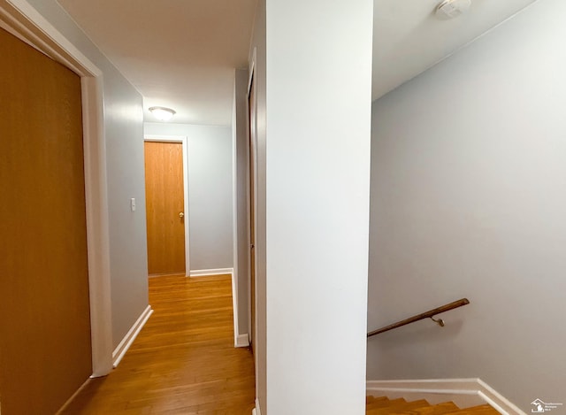 hall featuring baseboards and wood finished floors