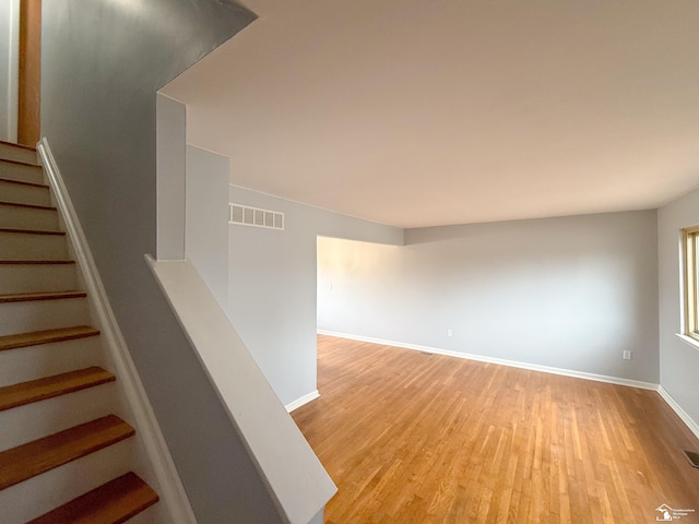 staircase with visible vents, baseboards, and wood finished floors