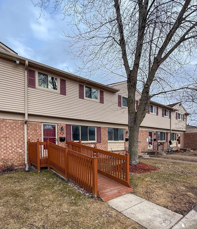 townhome / multi-family property featuring brick siding and a wooden deck