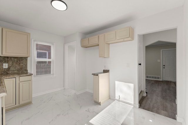 kitchen with visible vents, marble finish floor, cream cabinets, and baseboards