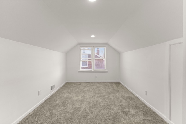 additional living space featuring lofted ceiling, carpet flooring, baseboards, and visible vents