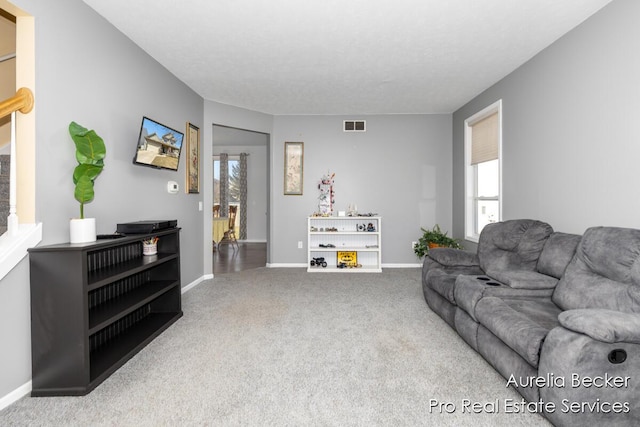 living room featuring visible vents, baseboards, and carpet