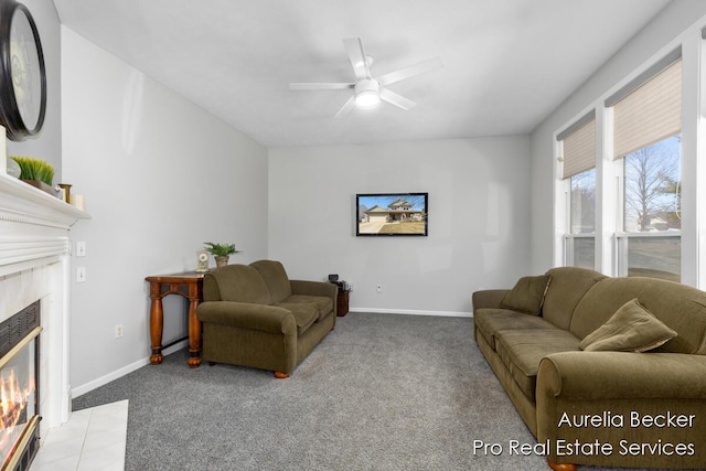 living room featuring light carpet, ceiling fan, baseboards, and a premium fireplace