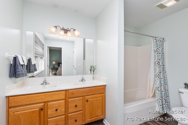 bathroom with a sink, shower / bathtub combination with curtain, toilet, and double vanity