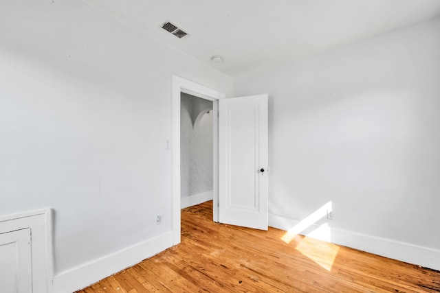 empty room featuring visible vents, light wood-style flooring, and baseboards