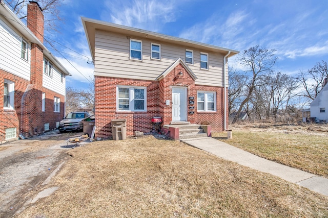 view of front facade featuring a front yard and brick siding