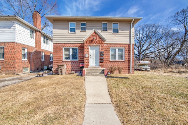 view of front of house featuring brick siding and a front yard