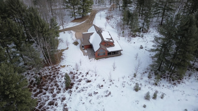 snowy aerial view with a wooded view