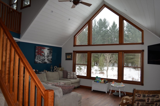 living room with wood finished floors, stairs, baseboards, and vaulted ceiling