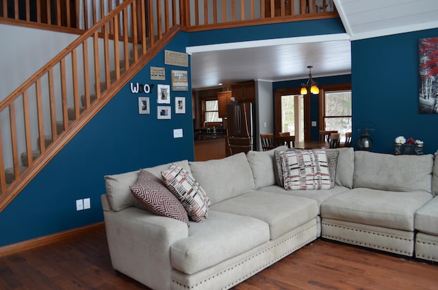 living room with stairway, wood finished floors, and baseboards