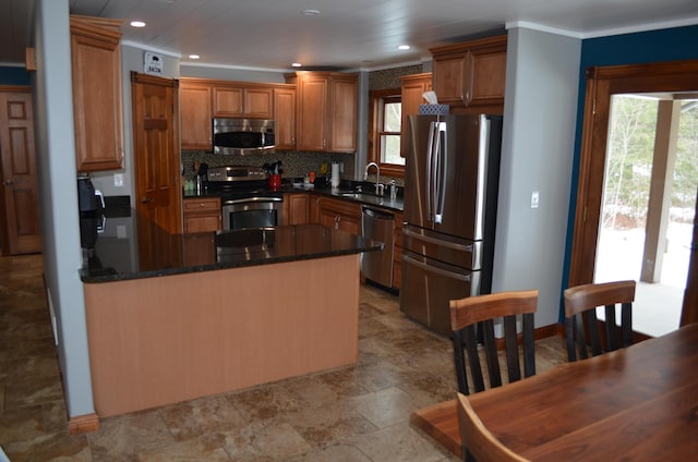 kitchen featuring decorative backsplash, a healthy amount of sunlight, a peninsula, and stainless steel appliances