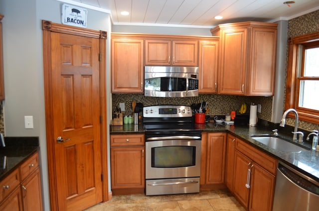 kitchen featuring a sink, stainless steel appliances, tasteful backsplash, and brown cabinetry