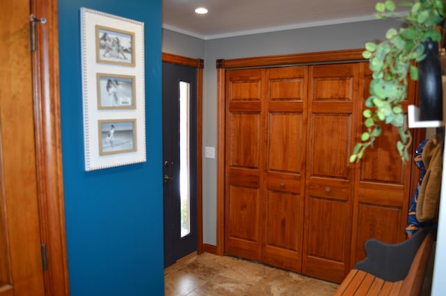 foyer entrance with crown molding, recessed lighting, and baseboards