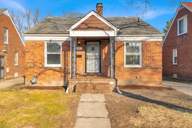 bungalow-style home featuring brick siding, a chimney, central AC, and roof with shingles