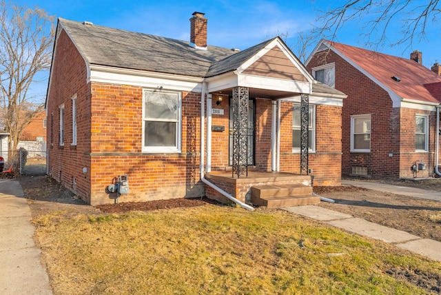 bungalow featuring a front yard, fence, brick siding, and a chimney