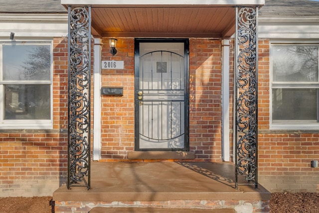 property entrance with brick siding and roof with shingles