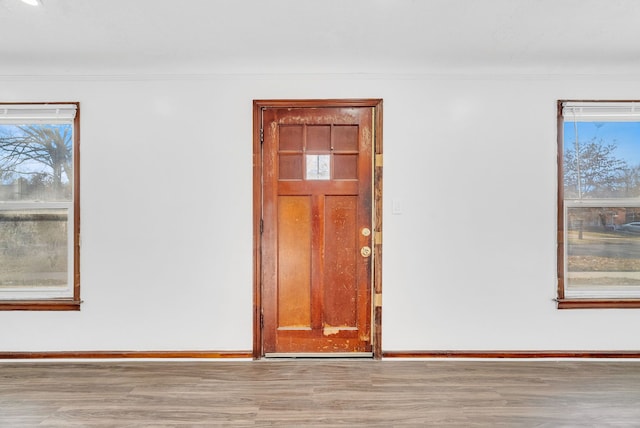 unfurnished room featuring baseboards, wood finished floors, and ornamental molding