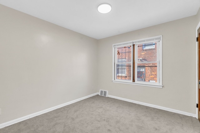 carpeted empty room featuring baseboards and visible vents