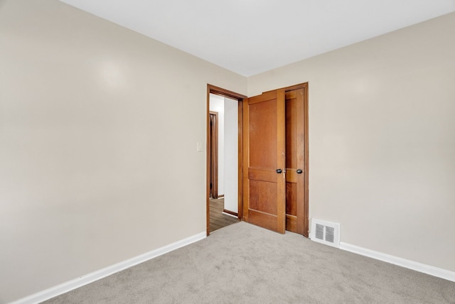 spare room with visible vents, baseboards, and carpet floors