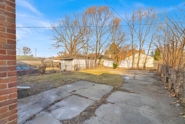 view of yard with an outdoor structure, a fenced backyard, and a patio area