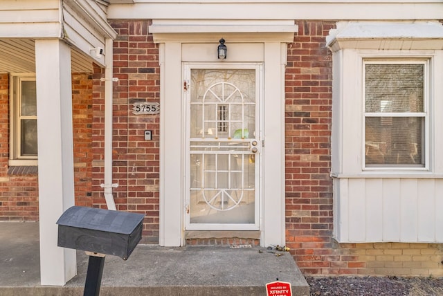 view of exterior entry featuring brick siding